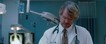 Movie still from “No Strings Attached” (2011), directed by Ivan Reitman – A man in a white lab coat with a stethoscope around his neck; Medium shot, Low angle