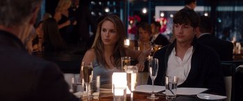 Movie still from “No Strings Attached” (2011), directed by Ivan Reitman – A beautiful young lady sitting at a dinner table; Medium shot, Over the shoulder angle