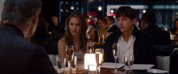 Movie still from “No Strings Attached” (2011), directed by Ivan Reitman – A woman sitting at a dinner table with a man; Medium shot, Over the shoulder angle