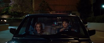 Movie still from “No Strings Attached” (2011), directed by Ivan Reitman – A man and a woman sitting in the back seat of a car; Medium shot, Over the shoulder angle