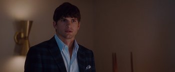 Movie still from “No Strings Attached” (2011), directed by Ivan Reitman – A man wearing a suit and tie in a dark room; Close Up shot, Over the shoulder angle