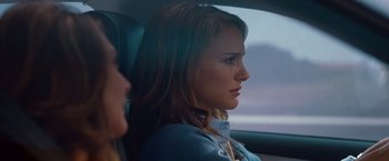 Movie still from “No Strings Attached” (2011), directed by Ivan Reitman – A woman sitting in the back seat of a car; Close Up shot, Over the shoulder angle