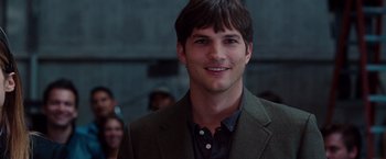 Movie still from “No Strings Attached” (2011), directed by Ivan Reitman – A man in a suit smiling for the camera; Close Up shot, Over the shoulder angle