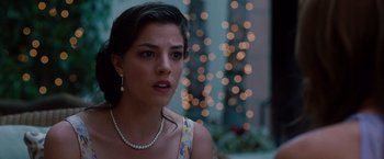 Movie still from “No Strings Attached” (2011), directed by Ivan Reitman – A woman wearing a pearl necklace and a dress; Close Up shot, Over the shoulder angle