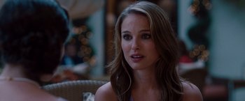 Movie still from “No Strings Attached” (2011), directed by Ivan Reitman – A beautiful woman with long brown hair sitting in a chair; Close Up shot, Over the shoulder angle