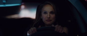 Movie still from “No Strings Attached” (2011), directed by Ivan Reitman – A beautiful woman sitting behind a steering wheel in the dark; Close Up shot, Over the shoulder angle