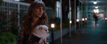 Movie still from “No Strings Attached” (2011), directed by Ivan Reitman – A woman holding a small white dog in her arms; Close Up shot, Over the shoulder angle