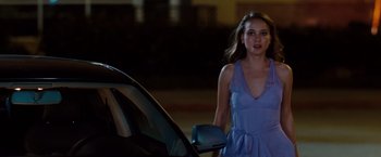 Movie still from “No Strings Attached” (2011), directed by Ivan Reitman – A beautiful young lady walking next to a parked car at night; Medium shot, Over the shoulder angle
