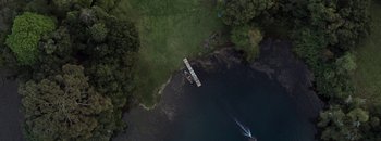 Movie still from “Nobody Knows I'm Here” (2020), directed by Gaspar Antillo – An aerial view of a body of water with a boat in it; Extreme Wide shot, Overhead angle