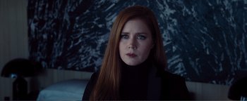 Movie still from “Nocturnal Animals” (2016), directed by Tom Ford – A woman with long red hair wearing a black top; Close Up shot, Over the shoulder angle