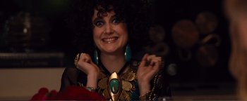 Movie still from “Nocturnal Animals” (2016), directed by Tom Ford – A woman wearing a necklace and earrings and smiling for the camera; Close Up shot, Over the shoulder angle