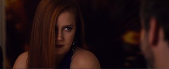 Movie still from “Nocturnal Animals” (2016), directed by Tom Ford – A woman with long red hair and blue eyes; Close Up shot, Over the shoulder angle