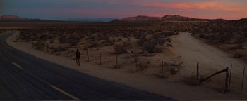 Movie still from “Nocturnal Animals” (2016), directed by Tom Ford – A person walking down a road in the desert; Extreme Wide shot, High angle