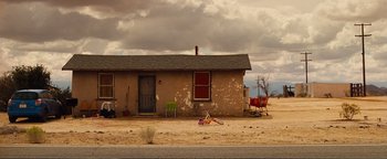 Movie still from “Nocturnal Animals” (2016), directed by Tom Ford – An old house with a lot of stuff on the ground outside; Extreme Wide shot, High angle