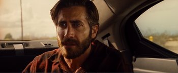 Movie still from “Nocturnal Animals” (2016), directed by Tom Ford – A person with a beard in a car; Close Up shot, Over the shoulder angle