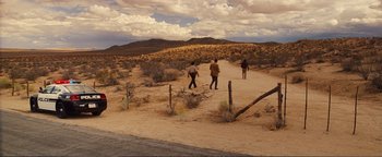 Movie still from “Nocturnal Animals” (2016), directed by Tom Ford – Three people walking down a dirt road in the desert; Extreme Wide shot, High angle