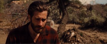 Movie still from “Nocturnal Animals” (2016), directed by Tom Ford – A person with a beard wearing a red shirt; Close Up shot, Over the shoulder angle