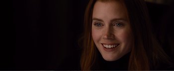 Movie still from “Nocturnal Animals” (2016), directed by Tom Ford – A person with a smile on their face; Close Up shot, Over the shoulder angle
