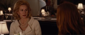 Movie still from “Nocturnal Animals” (2016), directed by Tom Ford – A woman wearing a white jacket and pearls sitting in front of a mirror; Medium shot, Over the shoulder angle