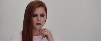 Movie still from “Nocturnal Animals” (2016), directed by Tom Ford – A woman with red hair is holding her hand to her face; Close Up shot, Over the shoulder angle