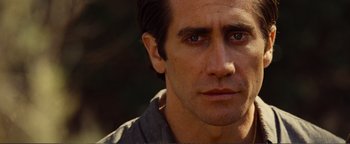 Movie still from “Nocturnal Animals” (2016), directed by Tom Ford – A man's face in a forest setting; Close Up shot, Low angle