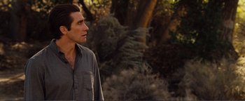 Movie still from “Nocturnal Animals” (2016), directed by Tom Ford – A man standing in front of some trees looking to his left; Close Up shot, Over the shoulder angle