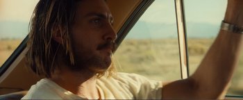 Movie still from “Nocturnal Animals” (2016), directed by Tom Ford – A man with long hair sitting in the driver's seat of a car; Close Up shot, Over the shoulder angle