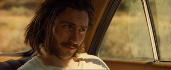 Movie still from “Nocturnal Animals” (2016), directed by Tom Ford – A person with long hair and a beard; Close Up shot, Over the shoulder angle