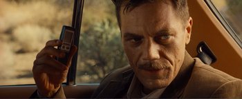 Movie still from “Nocturnal Animals” (2016), directed by Tom Ford – A person in a car with a gun; Close Up shot, Over the shoulder angle