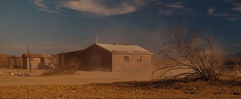 Movie still from “Nocturnal Animals” (2016), directed by Tom Ford – An old building in the middle of a dusty field; Extreme Wide shot, Low angle