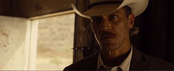 Movie still from “Nocturnal Animals” (2016), directed by Tom Ford – A person wearing a cowboy hat; Close Up shot, Over the shoulder angle