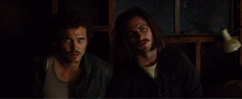 Movie still from “Nocturnal Animals” (2016), directed by Tom Ford – Two men with long dreadlocks are posing for a picture; Close Up shot, Low angle