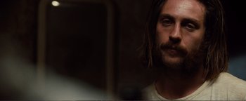 Movie still from “Nocturnal Animals” (2016), directed by Tom Ford – A person with long hair and a beard; Close Up shot, Over the shoulder angle