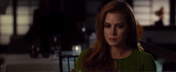 Movie still from “Nocturnal Animals” (2016), directed by Tom Ford – A person sitting at a table; Close Up shot, Over the shoulder angle