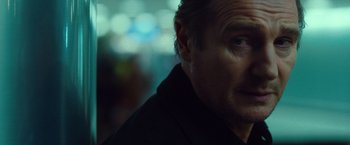 Movie still from “Non-Stop” (2014), directed by Jaume Collet-Serra – A man's face in a dark room; Close Up shot, Over the shoulder angle