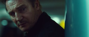 Movie still from “Non-Stop” (2014), directed by Jaume Collet-Serra – A man's face in the dark; Close Up shot, Over the shoulder angle