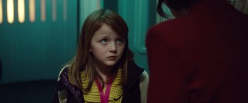 Movie still from “Non-Stop” (2014), directed by Jaume Collet-Serra – A young girl is sitting in front of a woman; Close Up shot, Over the shoulder angle