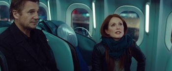 Movie still from “Non-Stop” (2014), directed by Jaume Collet-Serra – A woman sitting on a seat on a plane; Medium shot, Over the shoulder angle