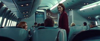 Movie still from “Non-Stop” (2014), directed by Jaume Collet-Serra – A woman standing next to a man on a plane; Medium shot, Over the shoulder angle