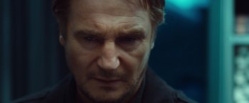 Movie still from “Non-Stop” (2014), directed by Jaume Collet-Serra – A man's face in a dark room; Close Up shot, Low angle