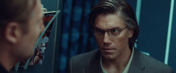Movie still from “Non-Stop” (2014), directed by Jaume Collet-Serra – A person wearing glasses and a suit; Close Up shot, Over the shoulder angle