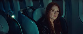 Movie still from “Non-Stop” (2014), directed by Jaume Collet-Serra – A woman sitting in a car looking at the camera; Close Up shot, Over the shoulder angle