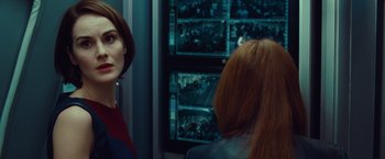 Movie still from “Non-Stop” (2014), directed by Jaume Collet-Serra – Two women are looking at a wall of pictures; Close Up shot, Over the shoulder angle