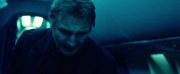 Movie still from “Non-Stop” (2014), directed by Jaume Collet-Serra – A person in a dark room; Close Up shot, Low angle