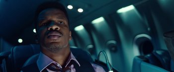 Movie still from “Non-Stop” (2014), directed by Jaume Collet-Serra – A person wearing a tie in a vehicle; Close Up shot, Low angle