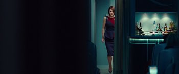 Movie still from “Non-Stop” (2014), directed by Jaume Collet-Serra – A woman walking through a doorway in a room; Medium shot, Over the shoulder angle