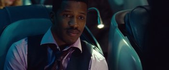 Movie still from “Non-Stop” (2014), directed by Jaume Collet-Serra – A man in a vest and tie sitting in a car; Close Up shot, Over the shoulder angle
