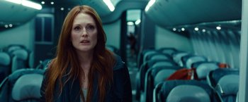 Movie still from “Non-Stop” (2014), directed by Jaume Collet-Serra – A woman standing on a train looking at the camera; Medium shot, Over the shoulder angle