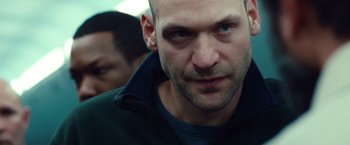 Movie still from “Non-Stop” (2014), directed by Jaume Collet-Serra – A man's face as he stares into the camera; Close Up shot, Over the shoulder angle