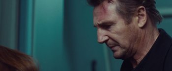 Movie still from “Non-Stop” (2014), directed by Jaume Collet-Serra – A man's face in a dark room; Close Up shot, Low angle